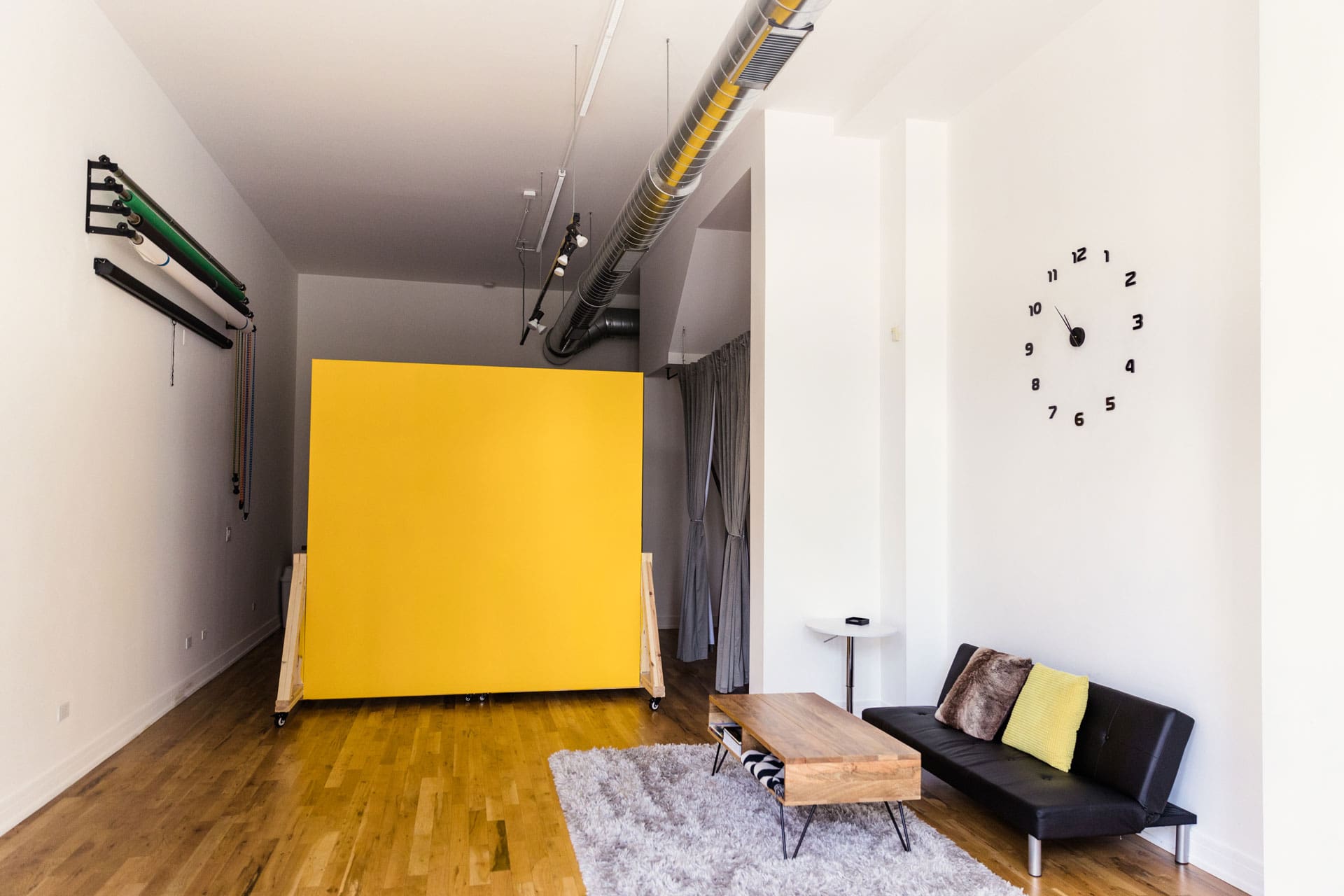 Interior of natural light photography studio P&M Studio Chicago including lounge area and yellow mobile wall