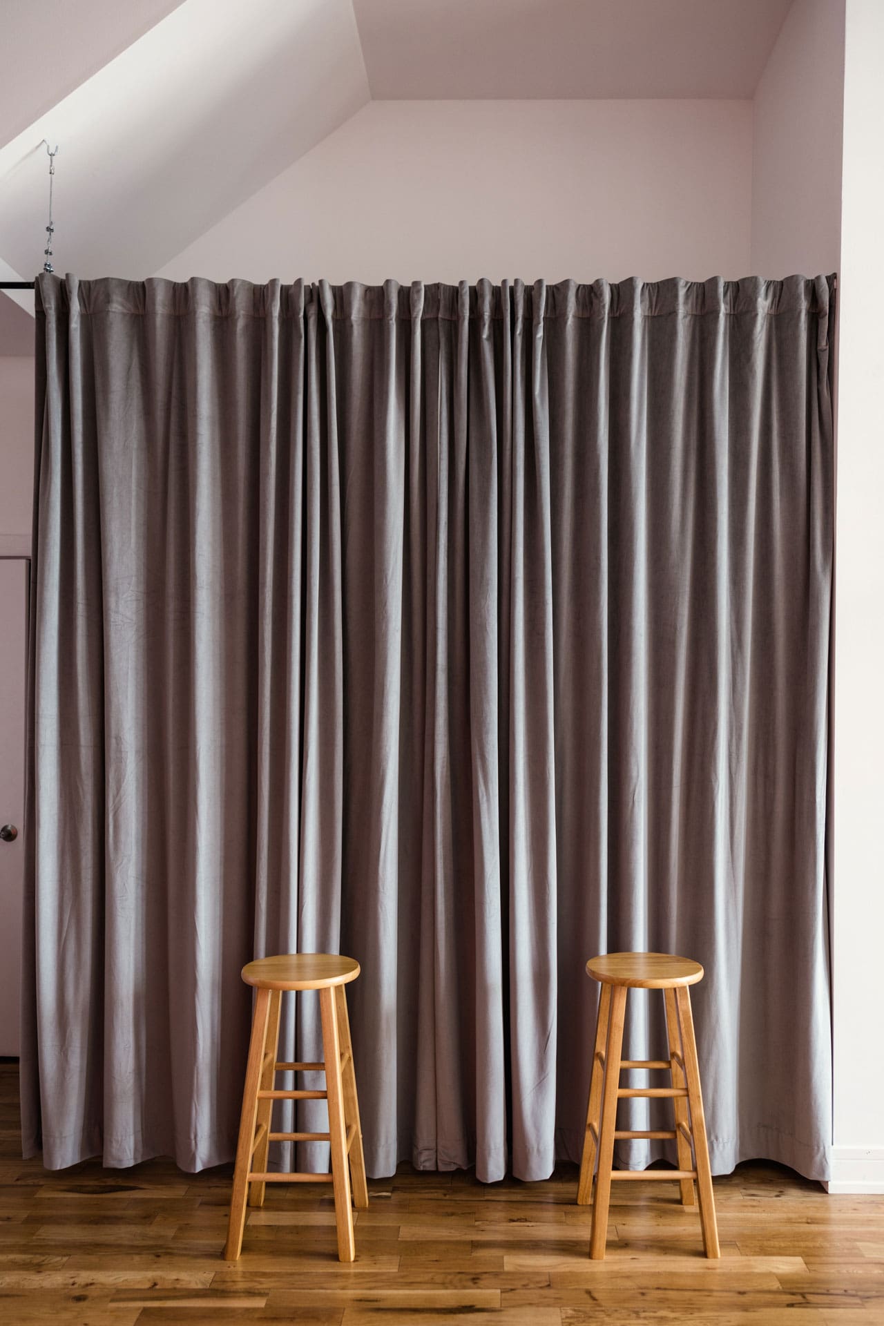 Gray dressing room curtains double as neutral backdrop with stools at Chicago photography studio P&M Studio