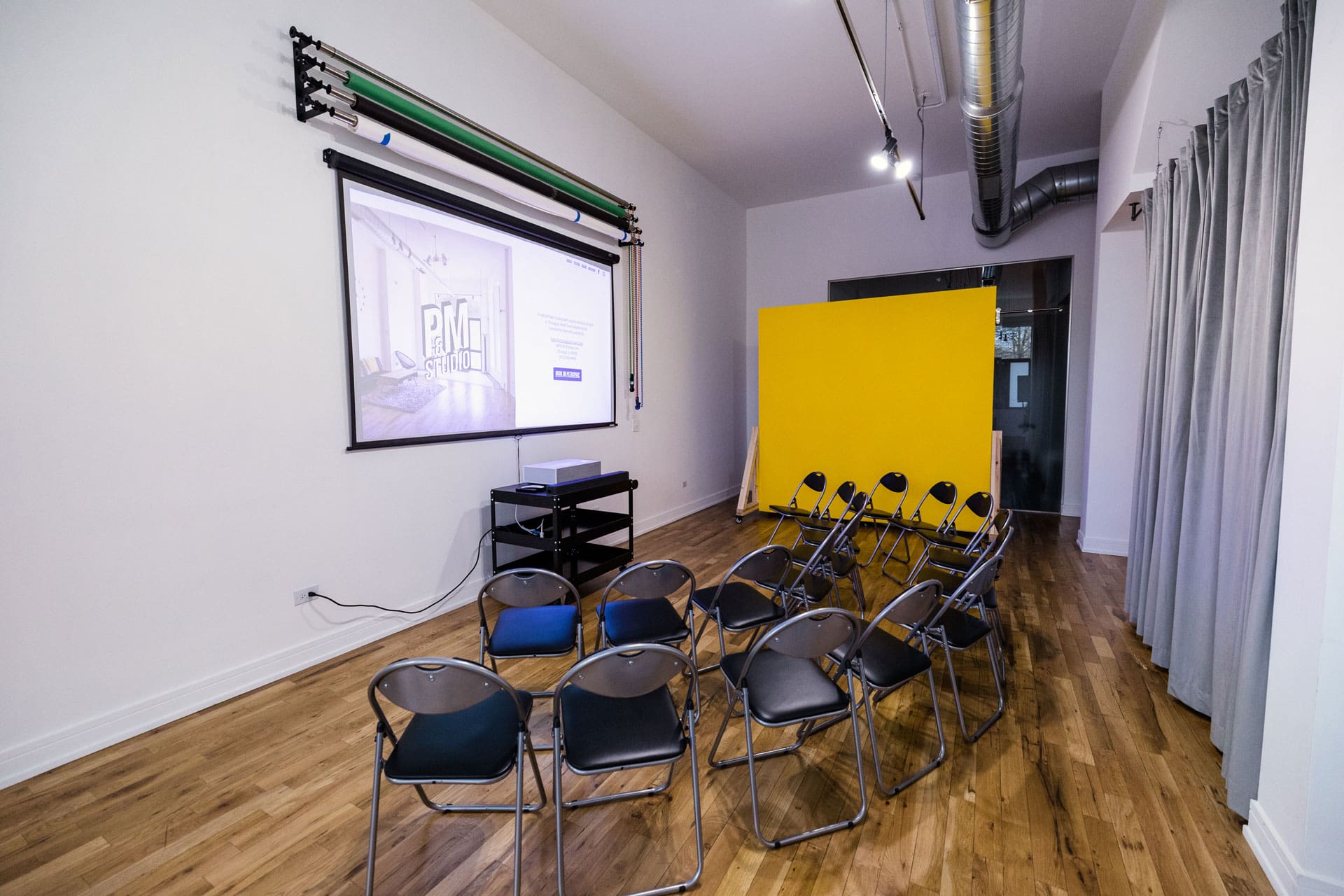 Meeting space with chairs set up to face projector screen at P&M Studio in Chicago's West Town neighborhood