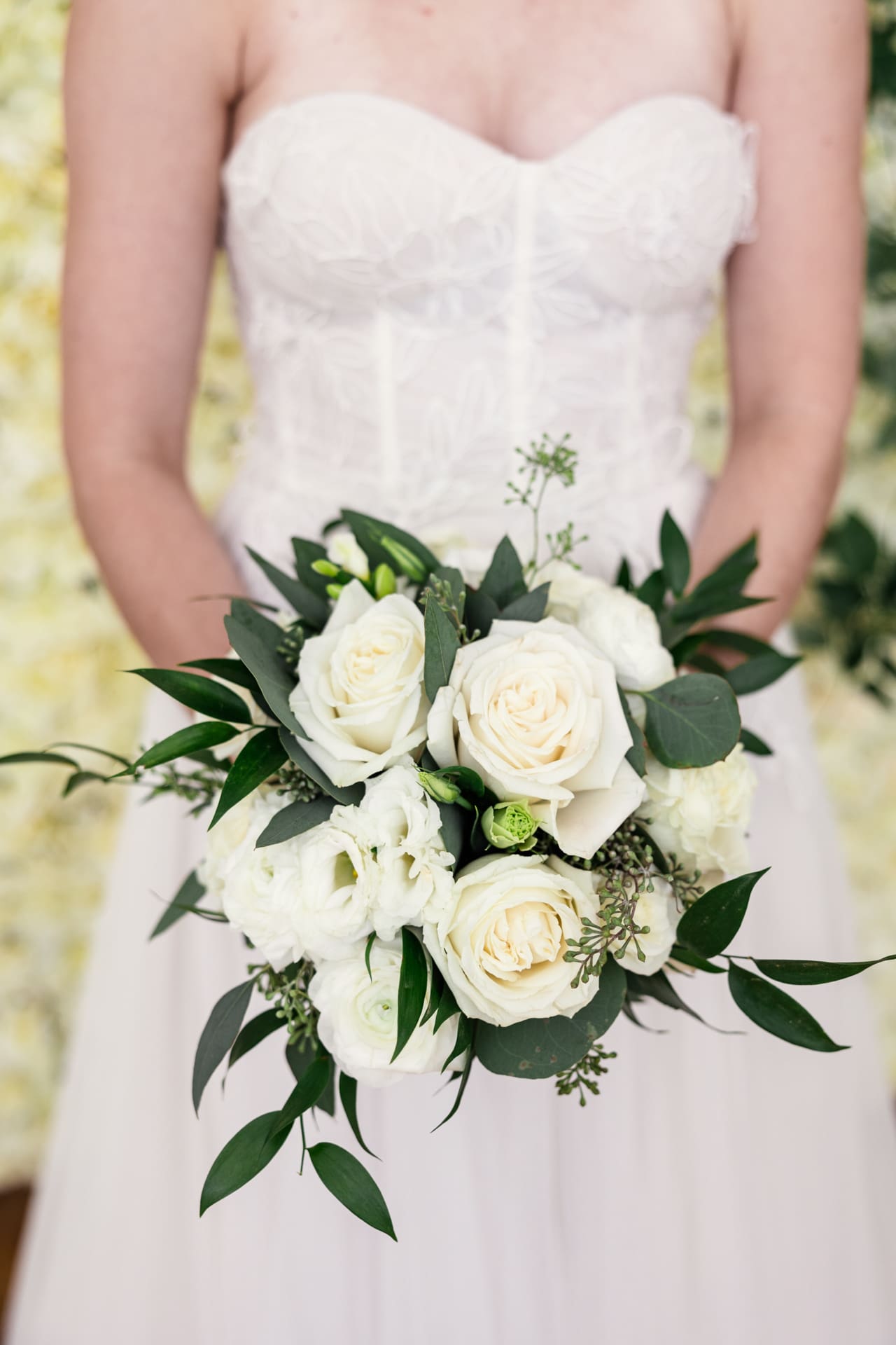 Detail photo of white floral bouquet and greenery in bride's hands at Chicago photography studio P&M Studio