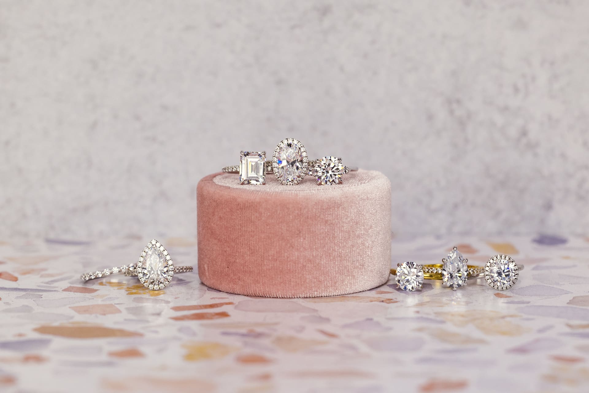 Jewelry product photo of diamond rings designed by Plum Diamonds sitting on pink ring box and pastel mosaic tile counter at Chicago photography studio P&M Studio