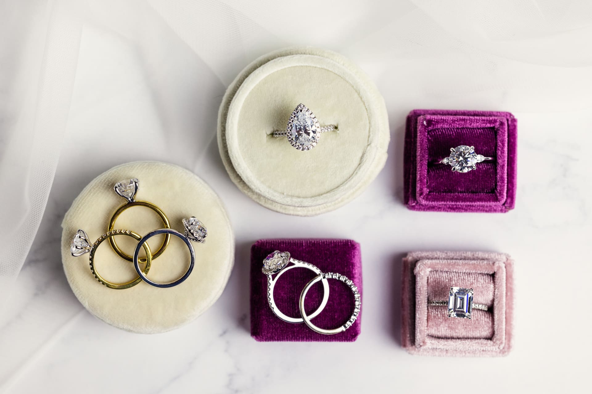 Jewelry product photography featuring a variety of diamond engagement rings and wedding bands on display in magenta, pink and white velvet ring boxes at Chicago photography studio P&M Studio