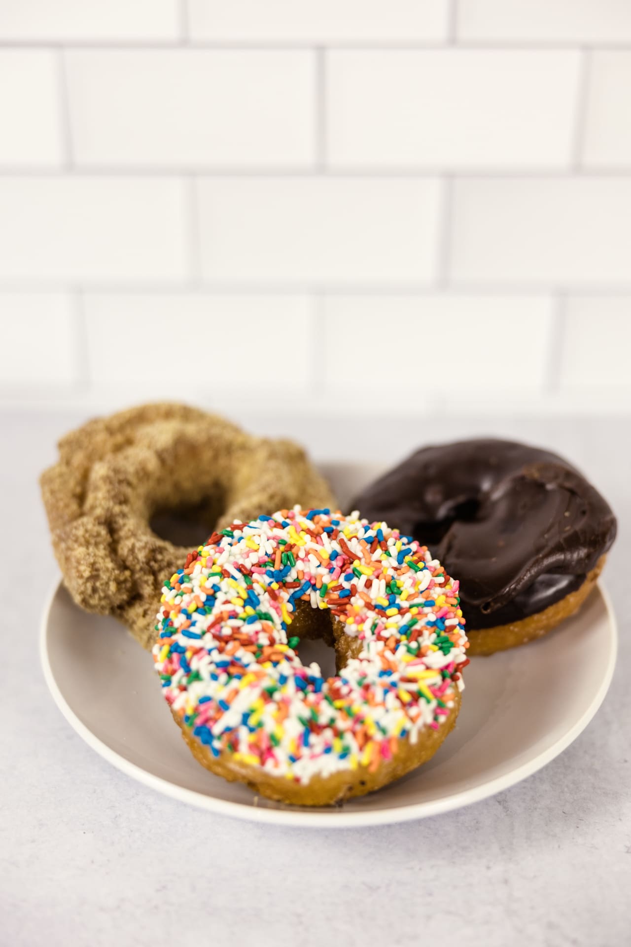 A chocolate, sprinkle, and cinnamon old-fashioned donut sit on plate in kitchen set at Chicago photography studio P&M Studio