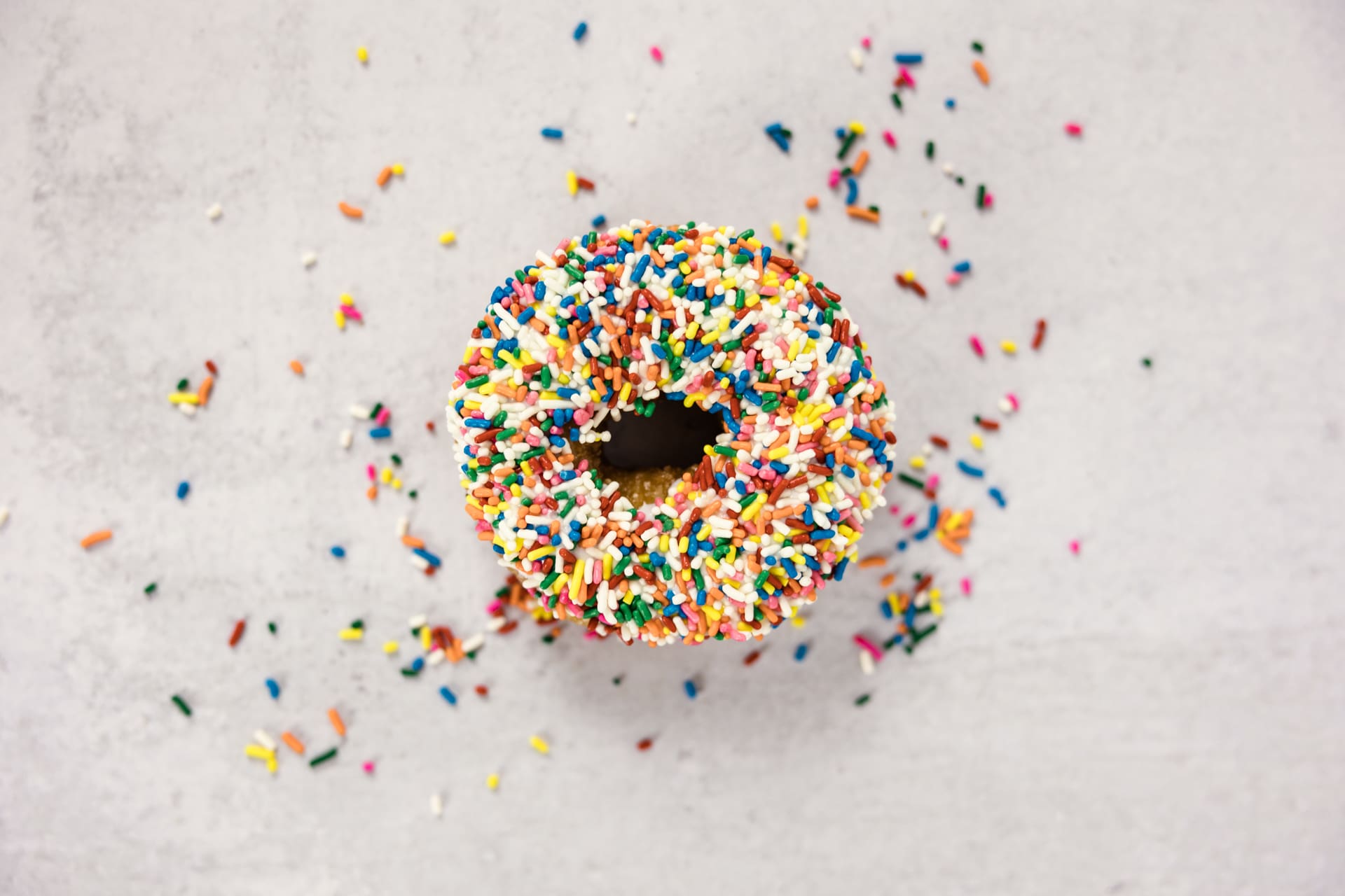 Food photography of one sprinkle donut with multiple colored sprinkles sitting on counter at Chicago photography studio P&M Studio