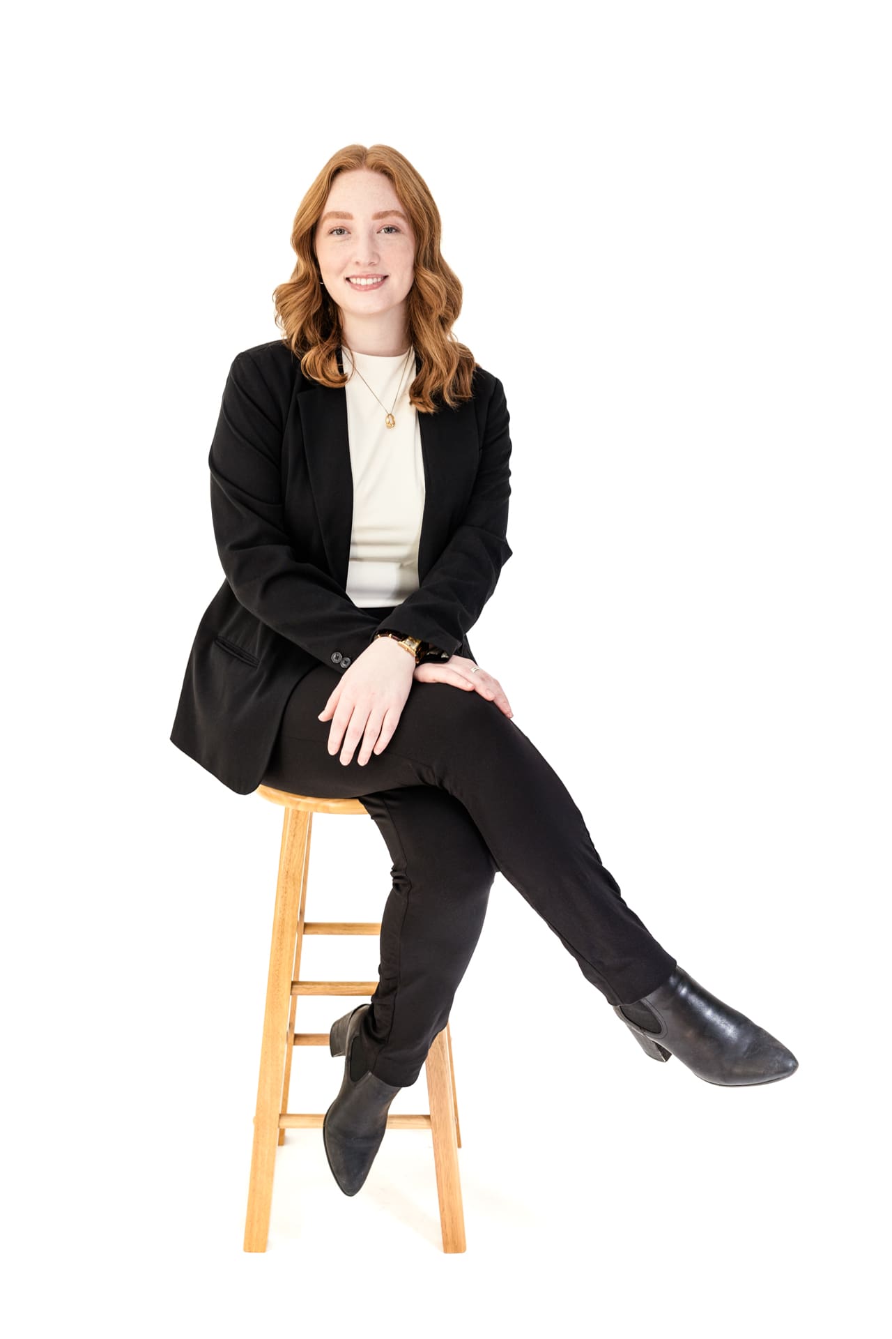 Studio portrait of woman wearing black suit sitting on stool at Chicago photography studio P&M Studio