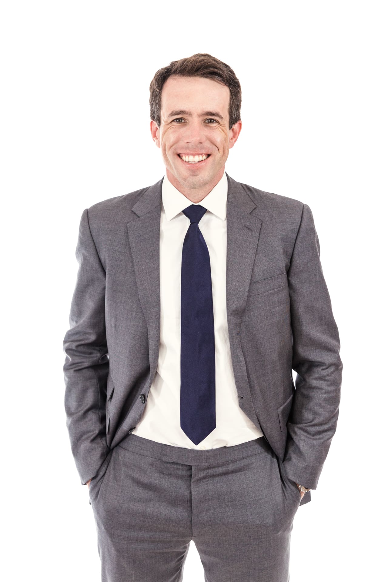 Headshot of man smiling in gray suit and blue tie with white backdrop at Chicago photography studio P&M Studio